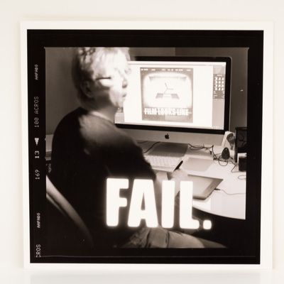 A frame of film, looking at a woman working on a photograph at her computer. She looks surprised. The title is overlaid in white macro text.