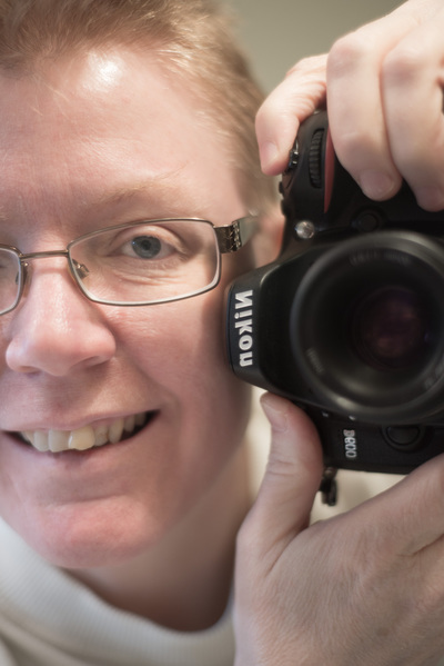 Head and camera fill the frame; mirror image