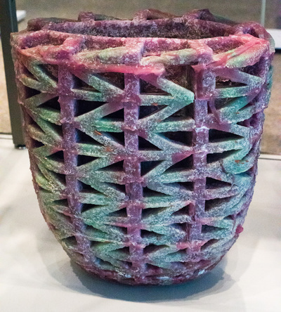 Dusty pink and aqua/green tall bowl/vase with arrow head shapes running horizontally around the length of it.